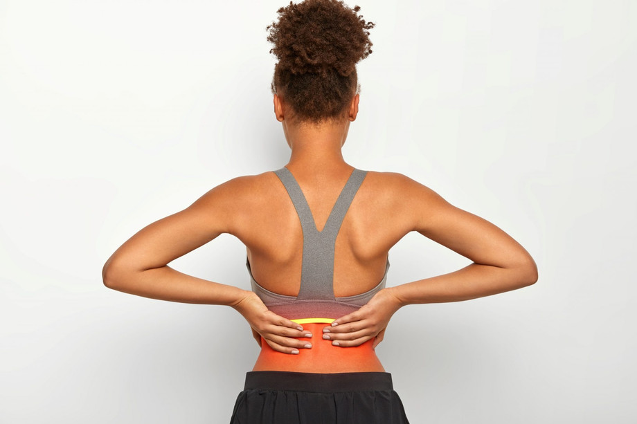 indoorshotfacelesscurlywomantouchesproblematiczonebacksuffersfrompainfulcrampsdressedcasualactivewearisolatedwhitebackgroundhealthcaremedicalconcept1024x683.jpg