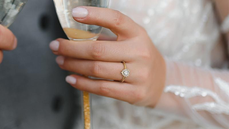 awomanwearingawhitegolddiamondhaloengagementring.jpg