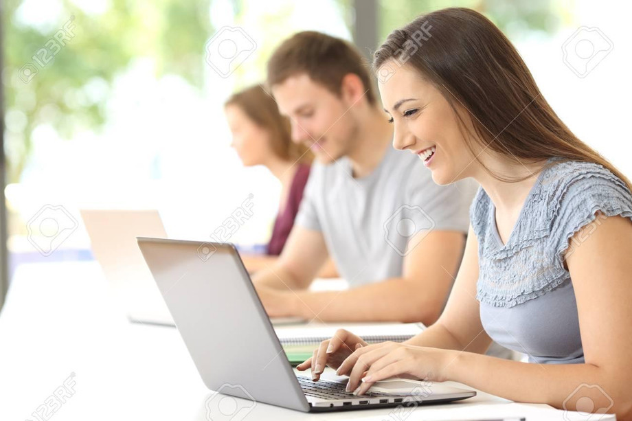 84001752-side-view-of-a-happy-student-searching-on-line-with-a-laptop-at-classroom.jpg