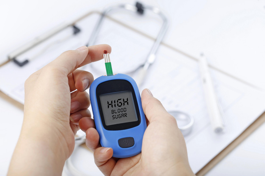 handholdingbloodglucosemetermeasuringbloodsugarbackgroundisstethoscopechartfile.jpg