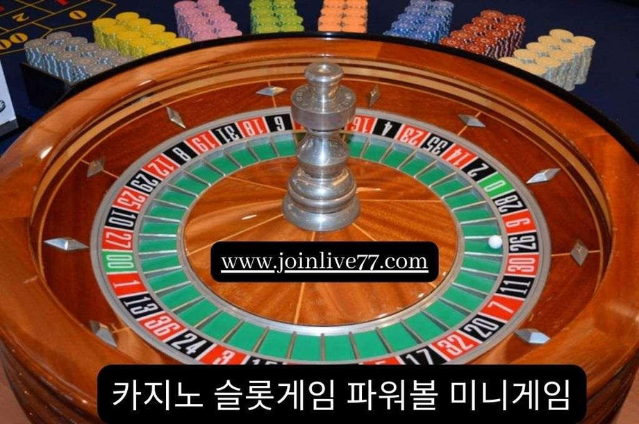 Wooden roulette wheel and different color of casino chips arrange on the side