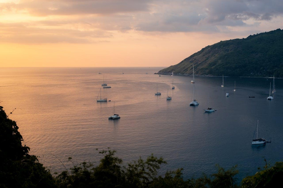 sailboatsyachtanchoredatthebaysunsetphuketthailand.jpg