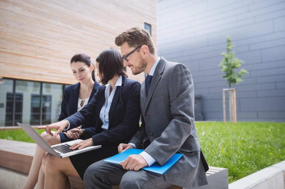businesswomansittingwithcolleaguesusinglaptop1.jpg