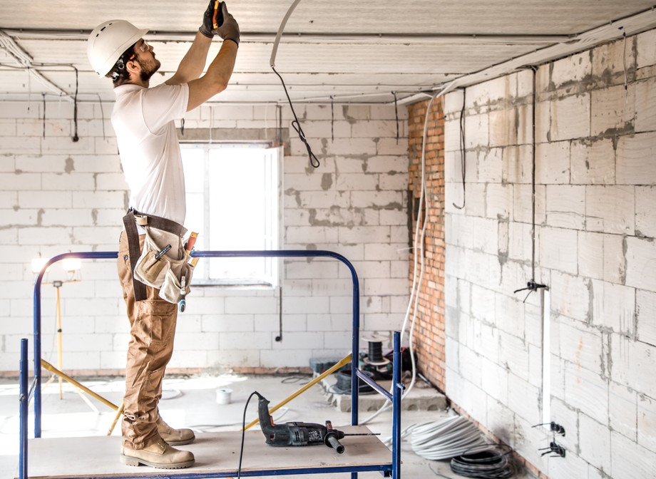 electricianinstallerwithtoolhishandsworkingwithcableconstructionsite.jpg