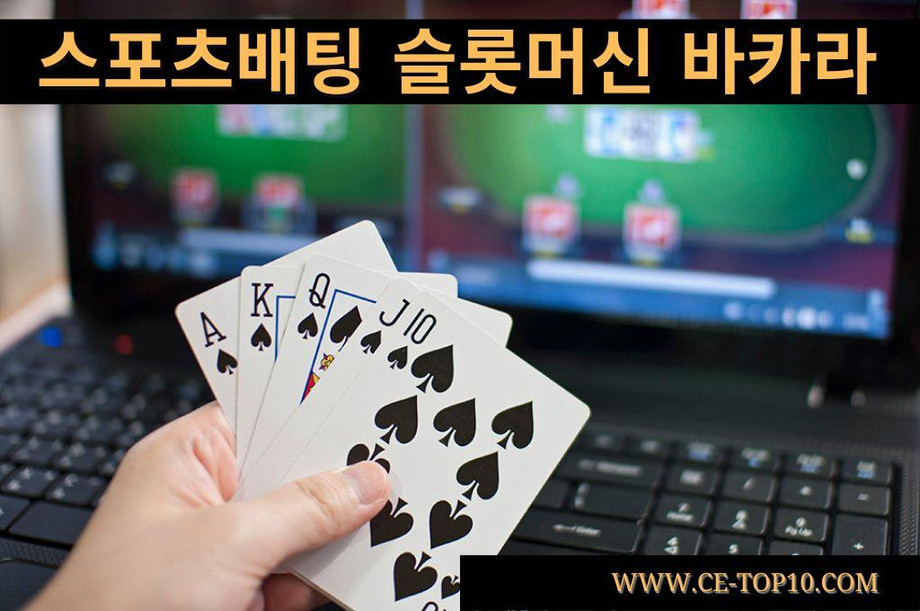 Hand holding cards in front of two black laptops