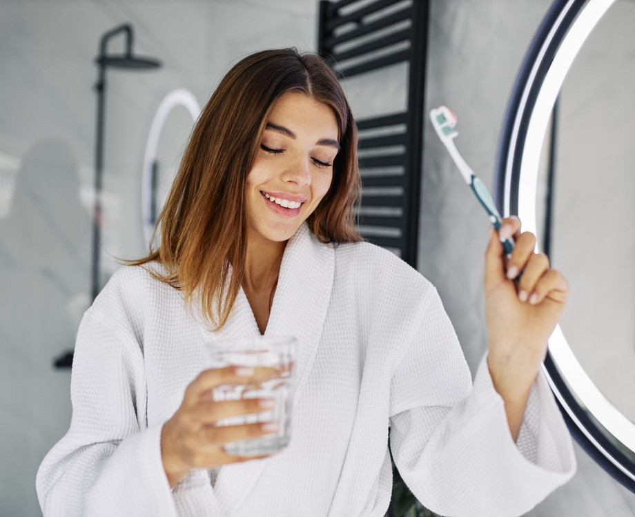 youngwomanholdingtoothbrushglasswater.jpg